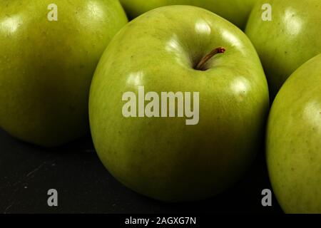 Nahaufnahme von grünen Äpfeln auf dem Schwarzen Brett, detaillierte Foto-Textur auf Apple Haut sichtbar. Stockfoto