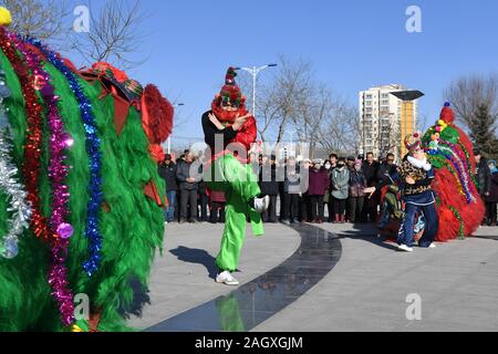 Yongdeng, China. 22 Dez, 2019. Folk Künstler proben Lion Dance für die bevorstehende chinesische Mondjahr in Yongdeng County, Lanzhou, der Hauptstadt der Provinz Gansu im Nordwesten Chinas, Dez. 22, 2019. Lion Dance ist eine traditionelle darstellende Kunst Chinas. Yongdeng Lion Dance, ein lokaler Stil von Lion Dance für seine unverwechselbare und komplizierte Bewegung bekannt, wurde als die immateriellen Kulturerbes der Provinz Gansu im Jahr 2011 aufgeführt. Der Löwe Kostüm, von Holzleisten im Inneren, ist etwa 2,8 Meter lang und 1,8 Meter hoch, so dass der Tanz eine anspruchsvolle Aufgabe für Künstler unterstützt. Quelle: Xinhua/Alamy L Stockfoto