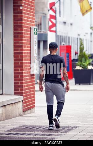 Montreal, Kanada - Juni, 2018: Sportlicher junger Mann mit seinem Körper mit Tätowierungen zu Fuß auf der Straße in Montreal, Quebec, Kanada. Stockfoto