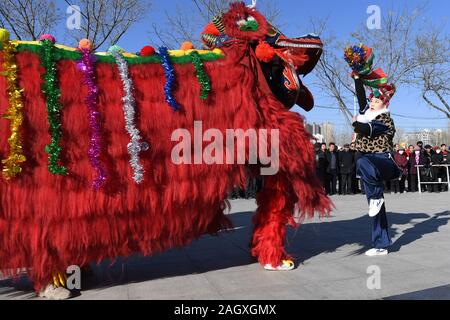 Yongdeng, China. 22 Dez, 2019. Folk Künstler proben Lion Dance für die bevorstehende chinesische Mondjahr in Yongdeng County, Lanzhou, der Hauptstadt der Provinz Gansu im Nordwesten Chinas, Dez. 22, 2019. Lion Dance ist eine traditionelle darstellende Kunst Chinas. Yongdeng Lion Dance, ein lokaler Stil von Lion Dance für seine unverwechselbare und komplizierte Bewegung bekannt, wurde als die immateriellen Kulturerbes der Provinz Gansu im Jahr 2011 aufgeführt. Der Löwe Kostüm, von Holzleisten im Inneren, ist etwa 2,8 Meter lang und 1,8 Meter hoch, so dass der Tanz eine anspruchsvolle Aufgabe für Künstler unterstützt. Quelle: Xinhua/Alamy L Stockfoto