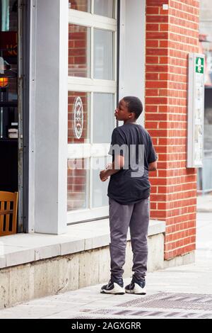 Montreal, Kanada - Juni, 2018: Afrikanische amerikanische Schwarze arme Junge auf der Straße zu einem Restaurant in Montreal, Kanada. Stockfoto