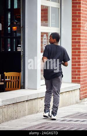 Montreal, Kanada - Juni, 2018: Afrikanische amerikanische Schwarze arme Junge auf der Straße zu einem Restaurant in Montreal, Kanada. Stockfoto