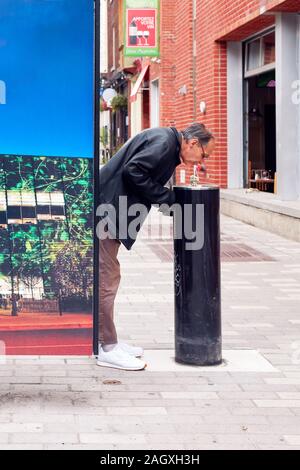 Montreal, Kanada - Juni, 2018: Der Mensch von Trinkwasser aus einer öffentlichen Wasserhahn auf der Straße in Montreal, Quebec, Kanada. Editorial. Stockfoto