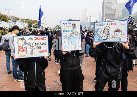 Die Demonstranten Plakate während der Demonstration Halten. 6. Monat der Unruhen, die demonstranten an einer Kundgebung in Solidarität mit den Uiguren in Xinjiang. Reden wurden der Organisatoren der Veranstaltung gegeben. Polizisten erschienen und wurden von maskierten Demonstranten konfrontiert. Stockfoto