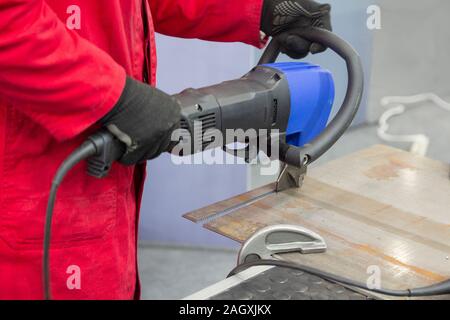 Männliche schneidet Metall hydraulik Werkzeug Hand. Metallbearbeitung Stockfoto