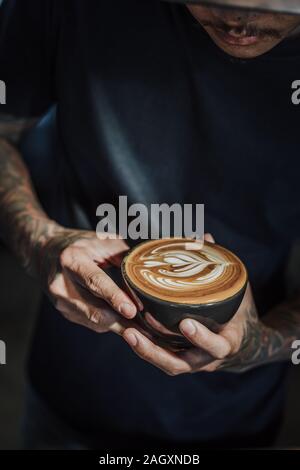 Kaffee latte Kunst machen von Barista in Coffee Shop Cafe vintage Farbton. Stockfoto