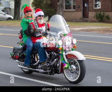 Pennsylvania, USA. 21 Dez, 2019. Debbie Kaelin von Bensalem, reitet auf dem Rücken einer Harley Davidson mit Gary Gifford von Bensalem, verkleidet als Weihnachtsmann, zusammen mit anderen Mitgliedern der Delaware Senke Bügeleisen indischen Riders Association, die ihre jährlichen Fahrt hielt der Weihnachtsmänner und Spielzeug für Kinder am Samstag, 21. Dezember 2019 in der St. Francis-St Vincent Home für Kinder in Bensalem, Pennsylvania. Credit: William Thomas Kain/Alamy leben Nachrichten Stockfoto