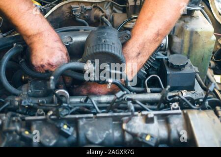 Close-up von mechanischen Instandsetzung eines Motors. Mann Hand in Öl Stockfoto