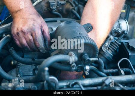 Close-up von mechanischen Instandsetzung eines Motors. Man Hände anzeigen unter der Haube. Stockfoto