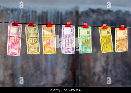 Selektiver Fokus der neuen indischen Banknoten Rupien zehn, zwanzig, fünfzig hundert, zweihundert, fünfhundert und zwei Tausend hängen in einem Kabel. Stockfoto