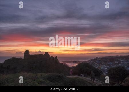 Hastings, East Sussex, Großbritannien. Dezember 2019. Farbenprächtiger Sonnenuntergang auf Schloss Hastings am kürzesten Tag des Jahres zur Wintersonnenwende. Stockfoto