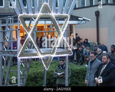 Bremen, Deutschland. 22 Dez, 2019. Rabbiner Natanel Teitelbaum spricht vor einer beleuchteten David Stern anlässlich der "Internationalen Nacht der Überlebenden" der Jewish Claims Conference für die chanukka Feier vor der Jüdischen Gemeinde. Die Zeremonie zu Ehren der Überlebenden des Holocaust wird auch in München, New York, Moskau, Paris und Jerusalem statt. Quelle: Jörg Sarbach/dpa/Alamy leben Nachrichten Stockfoto