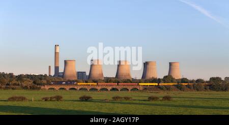 DRS-Klasse 66 66421 Lokomotiven, Long Eaton mit einem Güterzug mit Materialien für Network Rail. Ratcliffe power station hinter Stockfoto