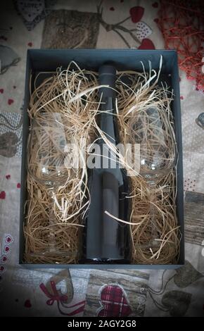Eine Flasche Rotwein und zwei Gläser als Geschenk verpackt Stockfoto