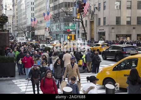 Massen von Touristen und New Yorker kick-off der Saison am "Schwarzen Freitag" auf der 5th Avenue an der 50th Street, die von Rockefeller Center in Midtown Manhatt Stockfoto