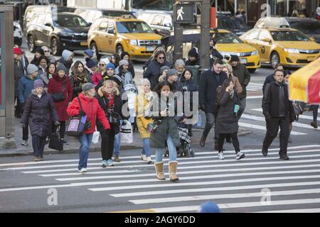 Fußgänger Kreuz 42nd Street auf der 5th Avenue am Schwarzen Freitag zum Auftakt der Holiday Shopping Season in New York City. Stockfoto