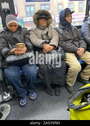 Die Menschen fahren an einem kalten späten Herbsttag mit einem MTA-Bus in New York in Brooklyn, New York. Stockfoto