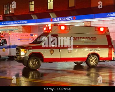 Krankenwagen Herausziehen von Maimonides Medical Center not Parkplatz in einem Notfall laufen an einem regnerischen Herbstnacht in Brooklyn, New York. Stockfoto