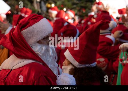 Genua, Italien - 22 Dezember 2019 - Traditionelle Santa Claus zu Fuß mehr als 2.000 Menschen Weihnachten gekleidet zu Fuß im Stadtzentrum Stockfoto