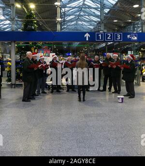 Carol Singers an Heuston Bahnhof, Dublin, Irland singen, Geld für eine obdachlose Liebe. Stockfoto