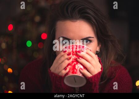 Frau winter Cup mit schönen Weihnachten Motiv schließen bis auf Weihnachten Hintergrund. Winter und Weihnachten Konzept. Stockfoto
