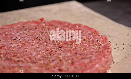 Kochen macht Fleisch Medaillons für Burger. Koch in schwarz Handschuhe macht Schnitzel essen. Die koteletts sind in Stahl Ring in eine noch Medaillon eingeebnet. Stockfoto