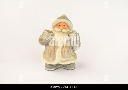 Santa Claus Doll mit Geschenken in den Händen, in Silber und Weiß gekleidet, auf weißem Hintergrund Stockfoto