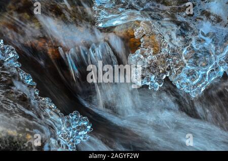 Detail gefrorener Bach - kleiner Wasserfall, Stein, Eiszapfen und milchig Stream Stockfoto