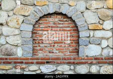 Steinmauer mit Gemauertem bis runde Fenster, geeigneten Platz für Text Stockfoto
