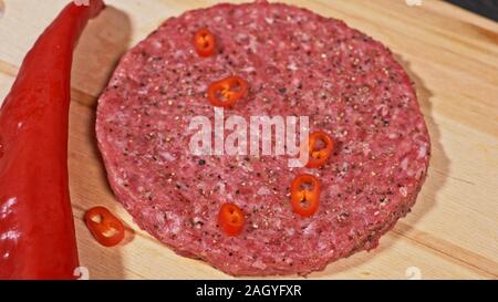 Kochen macht Fleisch Medaillons für Burger. Koch in schwarz Handschuhe macht Schnitzel essen. Die koteletts sind in Stahl Ring in eine noch Medaillon eingeebnet. Stockfoto
