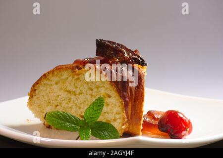 Teil der roscón de Reyes, typischen süßen Spaniens für 6. Januar eines jeden Jahres. Der Teller ist mit einem Zweig Minze und kandierten Früchten dekoriert, die Bott Stockfoto