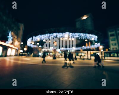 Defokussierten blur Blick auf den Place de l'Homme de Fer im Zentrum von Straßburg für Weihnachten dekoriert Urlaub mit Fußgänger warten auf die Straßenbahn in die Bahn-stationen Stockfoto