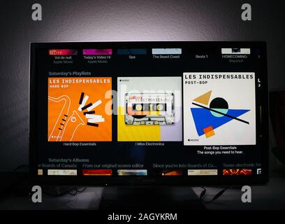 Paris, Frankreich, ca.2019: Mann surfen mit Remote Apple TV-Menü auf Panasonic Plasma tv Wohnzimmer surfen für die Artist's Playlisten Samstag Playlists Jazz, Funk, post-bop, Hard Bop, Stockfoto