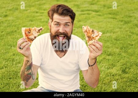 Eine Menge Pizza. bärtiger Mann hipster essen Pizza. glücklicher Mann student essen Pizza. Spaß. nähren wird warten. Sommer Picknick auf dem grünen Rasen. pizza Wochenende. Fast food. Ich Liebe Junk Food. Stockfoto