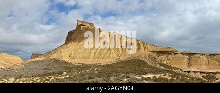 Geschichtete Berg mit einem Strauchigen Vorberg in den Badlands Bardenas Reales Stockfoto