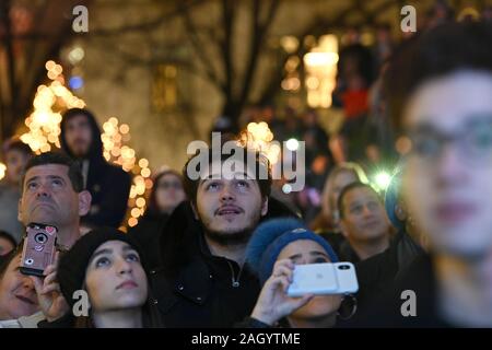 Menschen gether entlang Grand Army Plaza den weltweit größten Menorah zu beobachten Leuchten am ersten Abend Chanukka", in: New York, New York, am 22. Dezember 2019. Stehend 36 m hoch und mit einem Gewicht von 400 lbs, Hanukkah, bekannt als "Festival der Lichter" gefeiert für acht Tage von Juden weltweit. (Anthony Behar/Sipa USA) Stockfoto