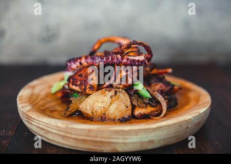 Spanisch pulpo serviert auf einem rustikalen Gericht in einem spanischen Tapas Bar in Nashville, TN. Stockfoto