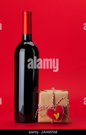 Valentinstag geschenk Box und Flasche Wein über den roten Hintergrund mit Kopie Raum für Ihre Grußansagen Stockfoto