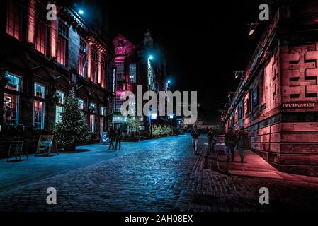 EDINBURGH, Schottland, 13. Dezember 2018: die Menschen zu Fuß entlang der Victoria Street und Ramsay Lane, in der Nacht durch bunt beleuchteten Gebäuden umgeben mit Stockfoto