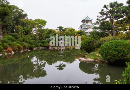 Die traditionellen japanischen Garten im Inneren bailey Burg von Osaka mit den fünf Geschichten Main Tower (tenshu) im Hintergrund. Chuo-ku. Osaka. Japan Stockfoto