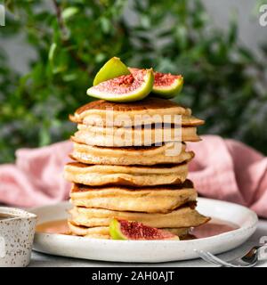 Stapel von lecker flauschigen Pfannkuchen mit frischen Feigen und Ahornsirup. Platz Orientierung. Süße Frühstück essen, reich an Kohlenhydraten und Gluten Stockfoto