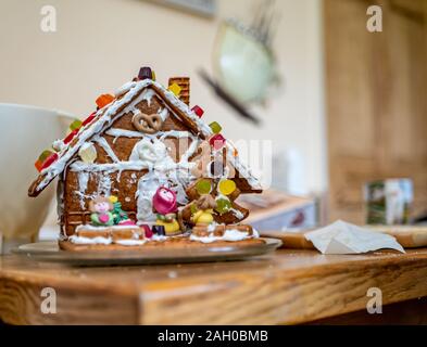 Hausgemachte und dekoriert Weihnachten Lebkuchen Haus gegen eine außerhalb des Fokus Hintergrund Stockfoto