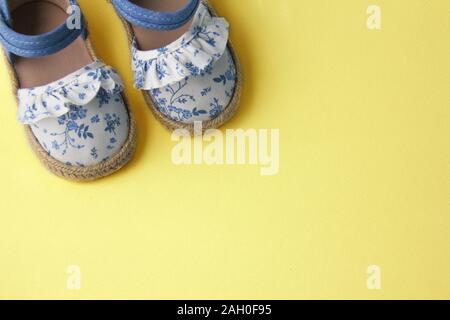 Blau Baby Schuhe auf gelbem Hintergrund Stockfoto