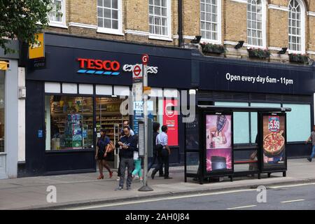 LONDON, Großbritannien - 7. JULI 2016: Menschen gehen von Tesco Express Lebensmittelgeschäft in London. Tesco hatte 5.500 Stores wie 2017. Stockfoto