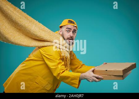 Medium studio geschossen von Pizza Mann abrutschen und herunterfallen, Türkis Hintergrund Stockfoto