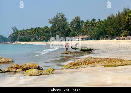 Zwei lokale Fischer an Land Anreise aus dem warmen Wasser der Bucht von Bengalen. Ngapali Beach, Rakhine, Myanmar Stockfoto