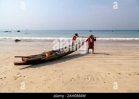 Zwei lokale Fischer an Land Anreise aus dem warmen Wasser der Bucht von Bengalen. Ngapali Beach, Rakhine, Myanmar Stockfoto