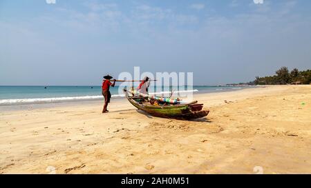 Zwei lokale Fischer an Land Anreise aus dem warmen Wasser der Bucht von Bengalen. Ngapali Beach, Rakhine, Myanmar Stockfoto