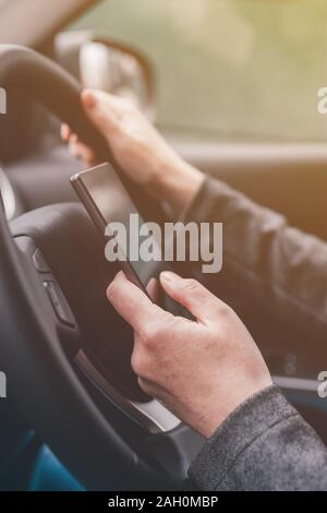 Texting und Fahren ist gefährlich Verhalten im Verkehr, in der Nähe der weiblichen Hand Eingeben von SMS auf Handy, während sie durch die Landschaft zu reisen Stockfoto