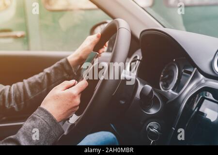 Texting und Fahren ist gefährlich Verhalten im Verkehr, in der Nähe der weiblichen Hand Eingeben von SMS auf Handy, während sie durch die Landschaft zu reisen Stockfoto